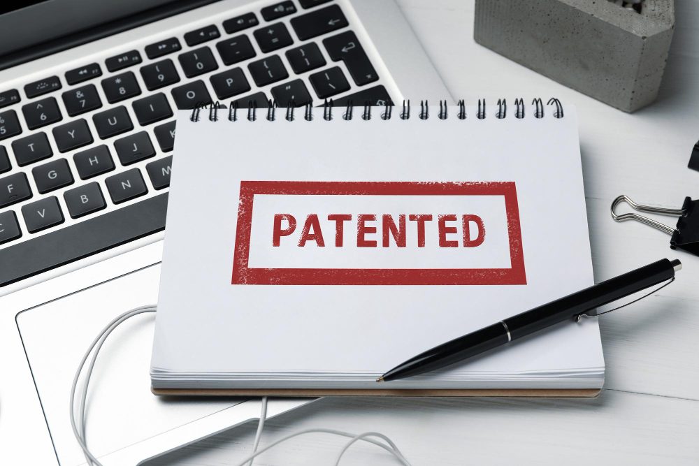 Documento com selo de patente, ao lado de um computador